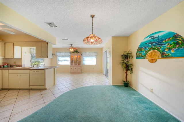 kitchen featuring cream cabinets, dishwasher, a textured ceiling, ceiling fan, and pendant lighting