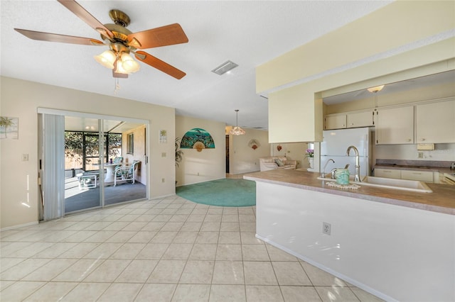 kitchen featuring sink, light tile patterned flooring, pendant lighting, white fridge, and ceiling fan