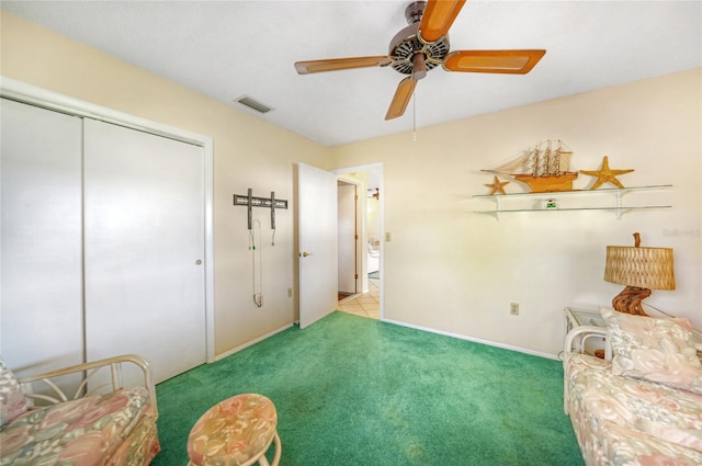 living area with light carpet and ceiling fan