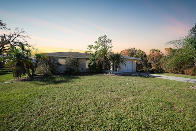 ranch-style home featuring a yard and a garage