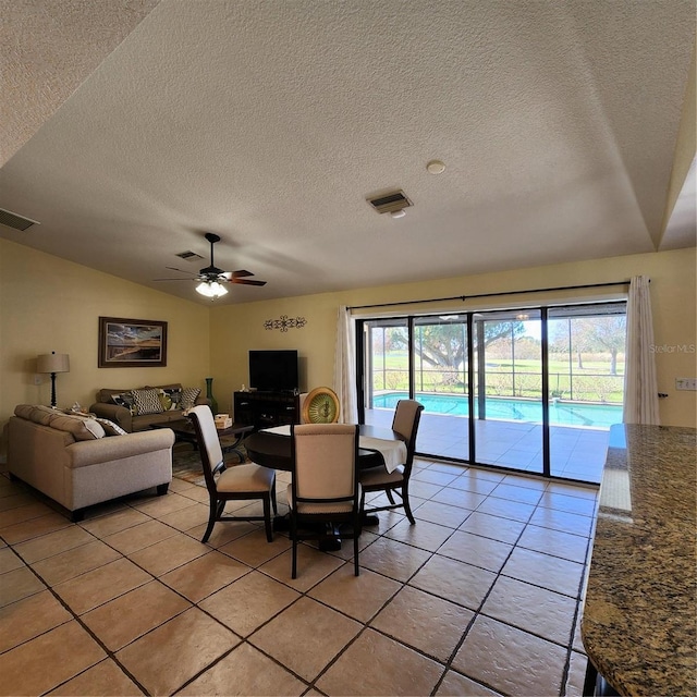 tiled dining area featuring a textured ceiling, plenty of natural light, and ceiling fan