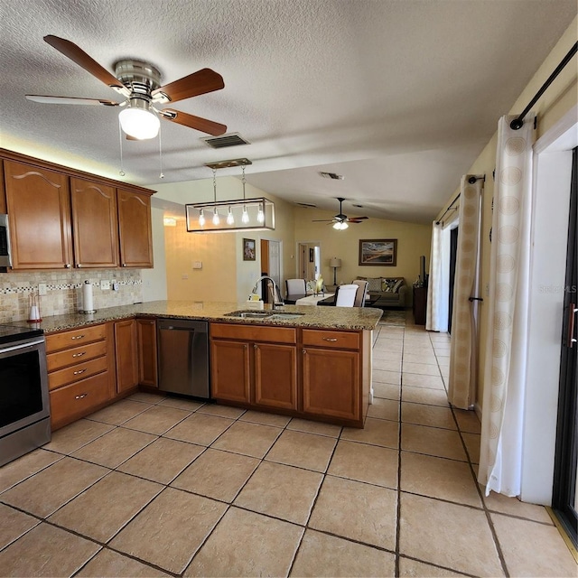 kitchen featuring kitchen peninsula, tasteful backsplash, stainless steel appliances, sink, and decorative light fixtures