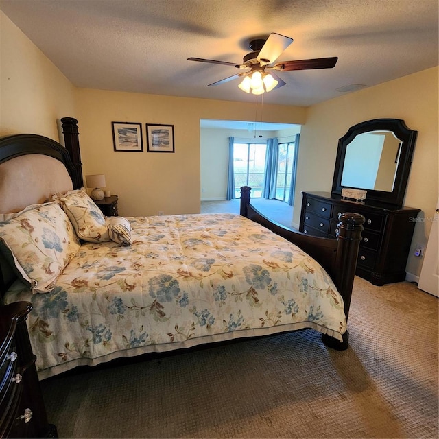 bedroom featuring a textured ceiling, carpet floors, and ceiling fan