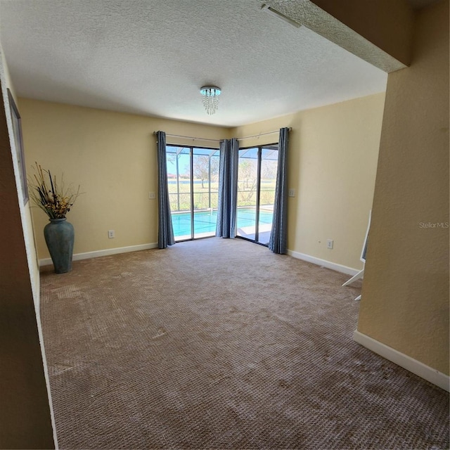 carpeted empty room with a textured ceiling