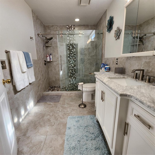 bathroom featuring vanity, toilet, tile walls, and an enclosed shower