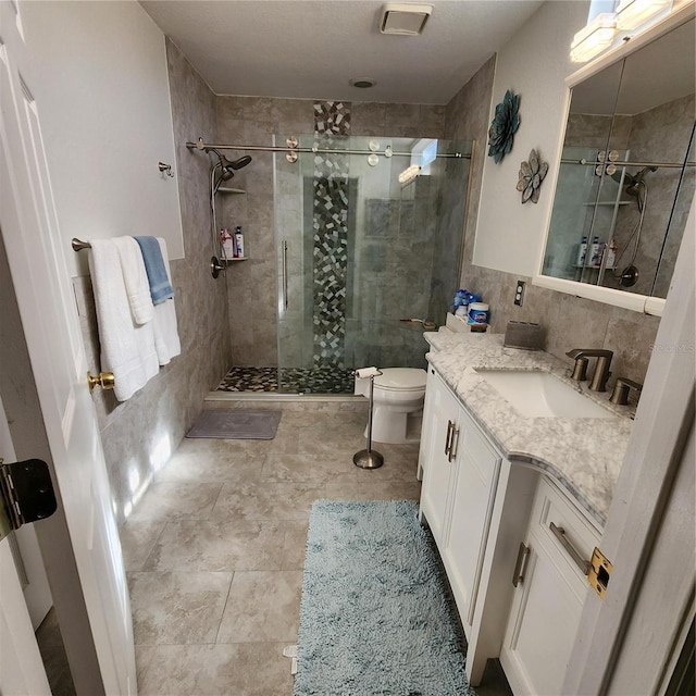 bathroom featuring backsplash, a shower with shower door, toilet, tile walls, and vanity