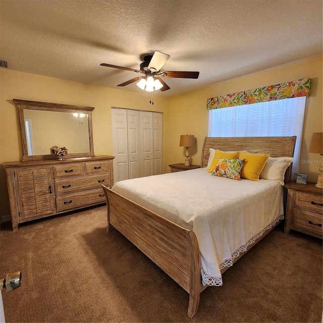 bedroom with a closet, ceiling fan, a textured ceiling, and dark colored carpet