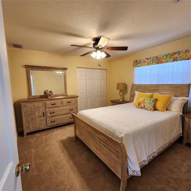 carpeted bedroom featuring a textured ceiling, a closet, and ceiling fan