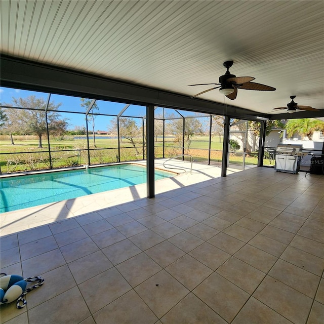 view of swimming pool featuring a patio, ceiling fan, and glass enclosure