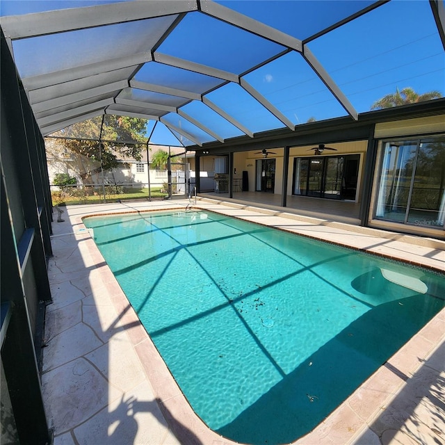 view of pool featuring ceiling fan, glass enclosure, and a patio area