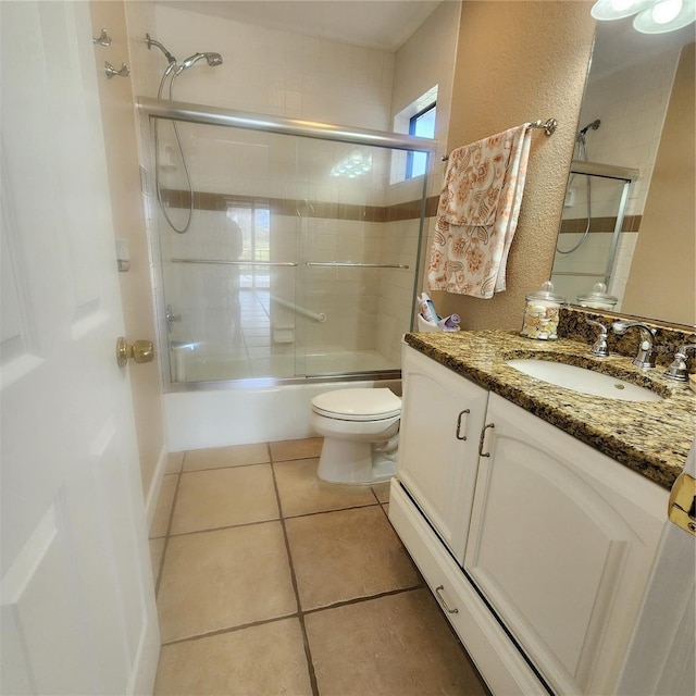 full bathroom with a baseboard radiator, shower / bath combination with glass door, toilet, vanity, and tile patterned flooring