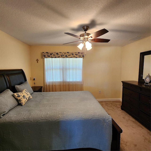 carpeted bedroom featuring a textured ceiling and ceiling fan