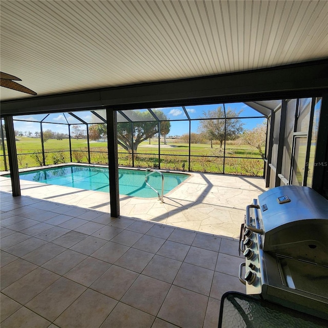 pool with glass enclosure, area for grilling, and a patio area