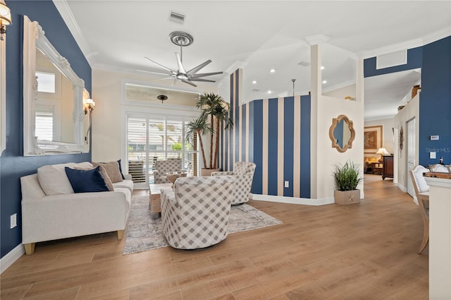 living room with ceiling fan, plenty of natural light, crown molding, and light hardwood / wood-style floors