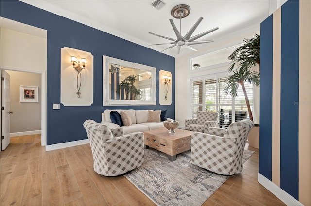 living room featuring light hardwood / wood-style floors, crown molding, and ceiling fan