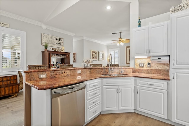 kitchen featuring kitchen peninsula, dark stone countertops, dishwasher, white cabinets, and sink