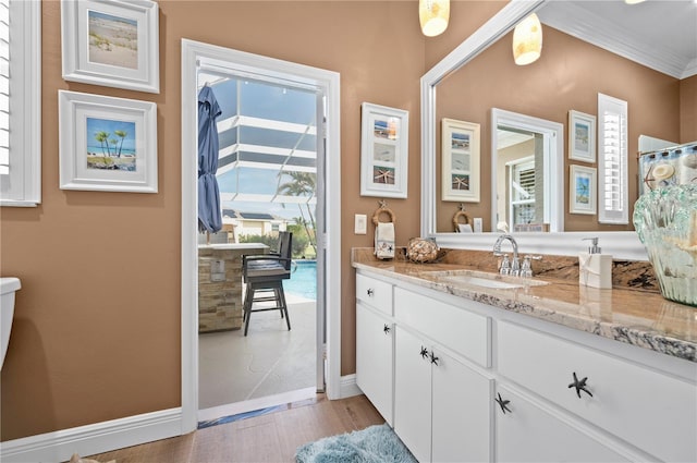 bathroom featuring vanity, crown molding, and hardwood / wood-style flooring