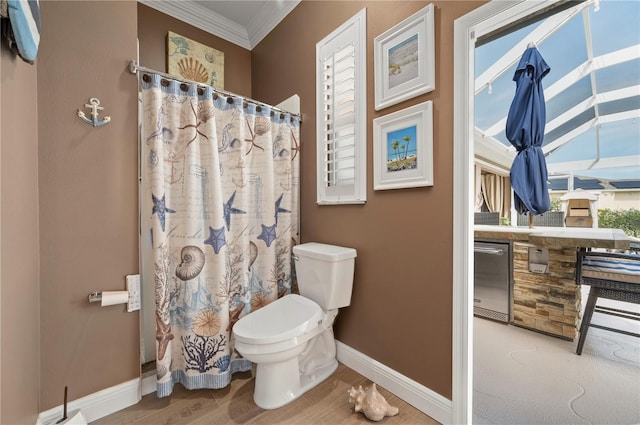 bathroom featuring toilet, crown molding, a shower with curtain, and hardwood / wood-style floors