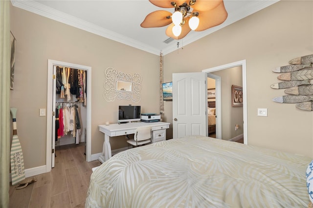 bedroom with light wood-type flooring, a closet, a walk in closet, and crown molding