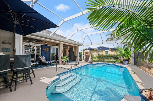 view of swimming pool with a lanai, ceiling fan, and a patio area