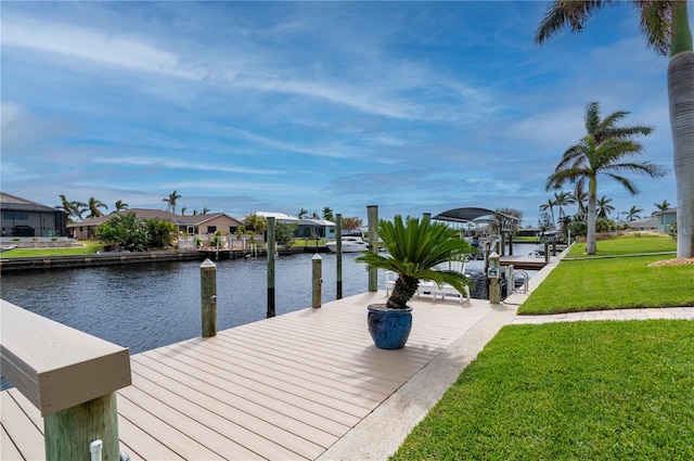 view of dock with a yard and a water view