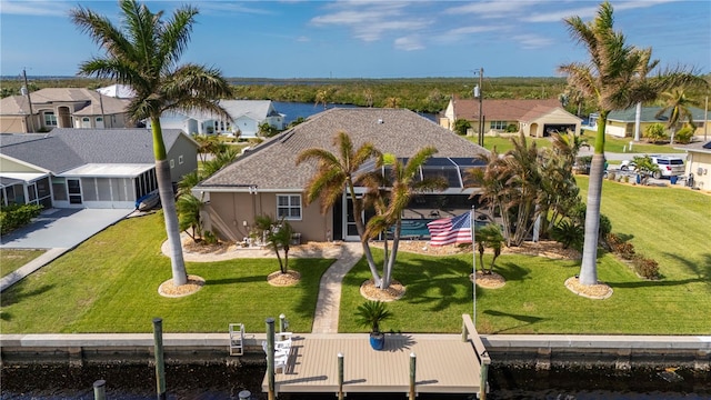 back of property featuring a lanai, a water view, and a lawn