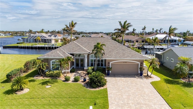 view of front of property featuring a garage, a front lawn, and a water view