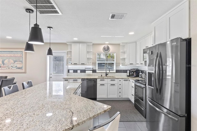 kitchen featuring pendant lighting, sink, appliances with stainless steel finishes, white cabinetry, and a kitchen breakfast bar