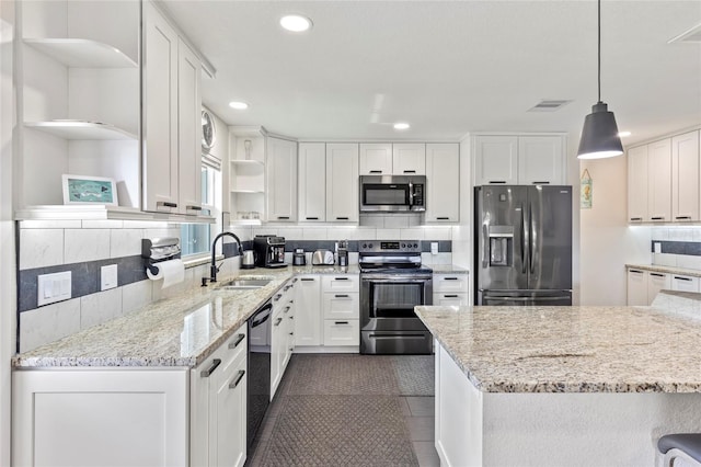 kitchen with appliances with stainless steel finishes, sink, hanging light fixtures, and white cabinets