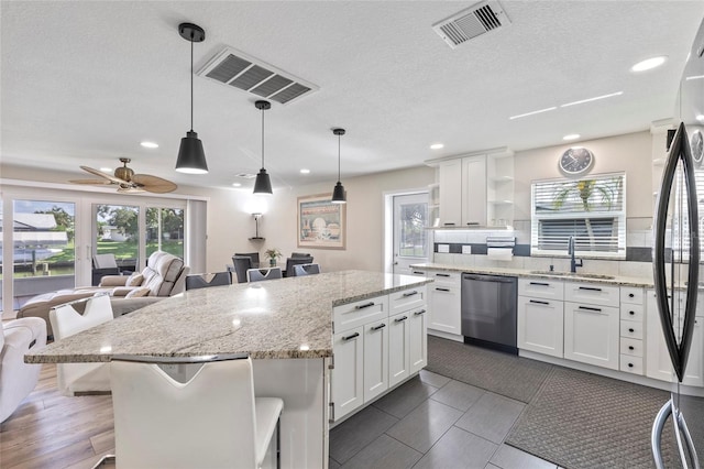 kitchen featuring white cabinetry, sink, stainless steel dishwasher, and backsplash