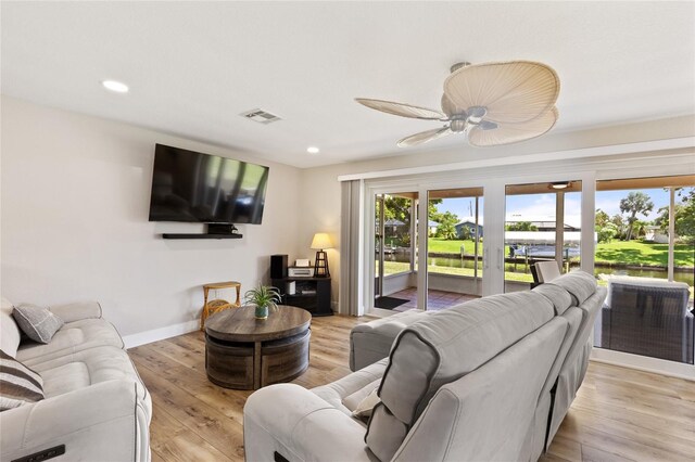 living room featuring light hardwood / wood-style flooring and ceiling fan