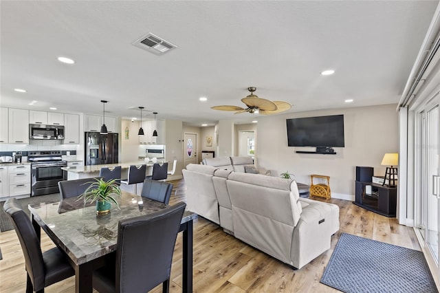 dining area featuring ceiling fan and light wood-type flooring