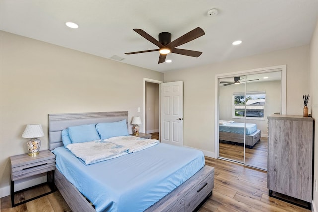 bedroom with a closet, ceiling fan, and light wood-type flooring