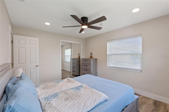 bedroom with a closet, ceiling fan, and light wood-type flooring