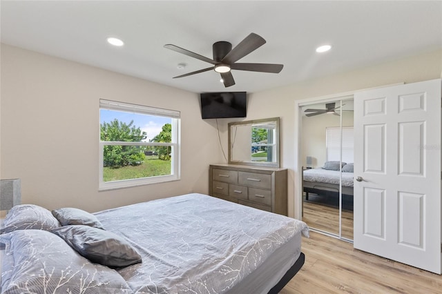 bedroom featuring light hardwood / wood-style floors, ceiling fan, and a closet