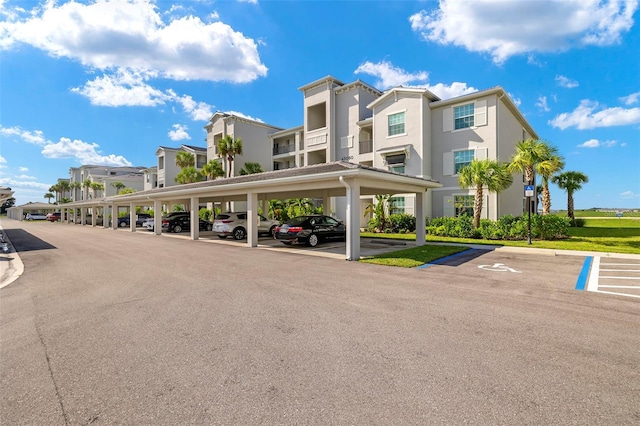 view of car parking featuring a lawn and a carport