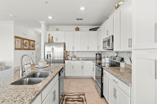 kitchen with light stone countertops, sink, white cabinetry, stainless steel appliances, and ornamental molding