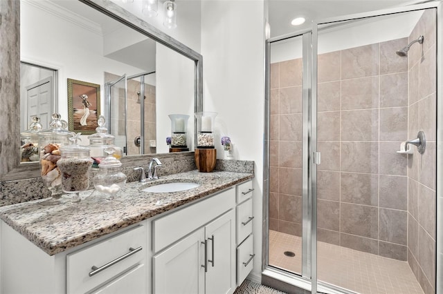 bathroom with vanity, crown molding, and walk in shower