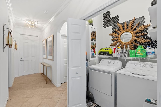 laundry room featuring independent washer and dryer, ornamental molding, and light tile patterned floors