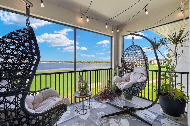 sunroom featuring a water view