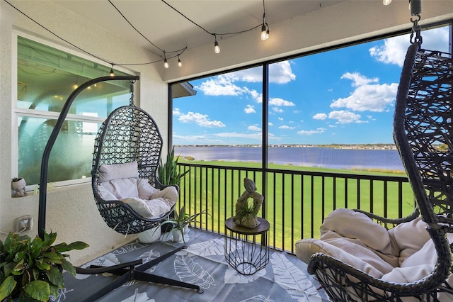 sunroom featuring a water view