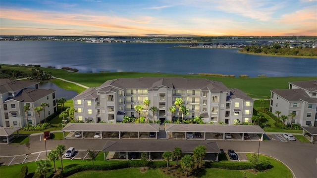 aerial view at dusk featuring a water view