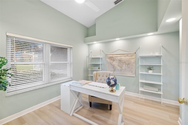 home office with light wood-type flooring, high vaulted ceiling, and ceiling fan