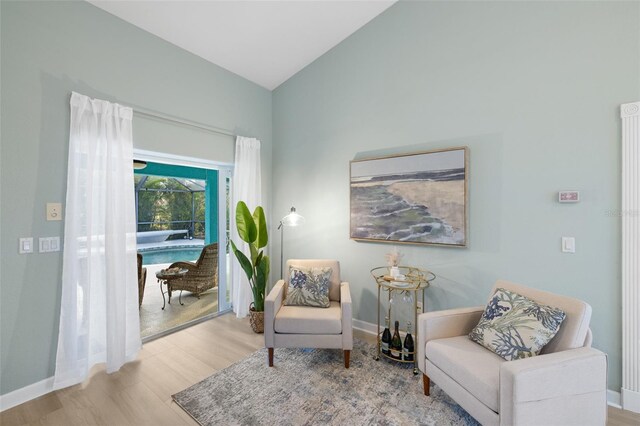 living area featuring light hardwood / wood-style flooring and vaulted ceiling