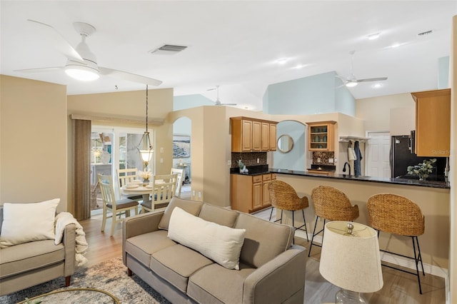 living room featuring lofted ceiling and light hardwood / wood-style flooring