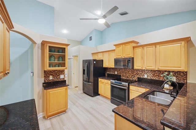 kitchen featuring decorative backsplash, dark stone counters, stainless steel appliances, sink, and high vaulted ceiling