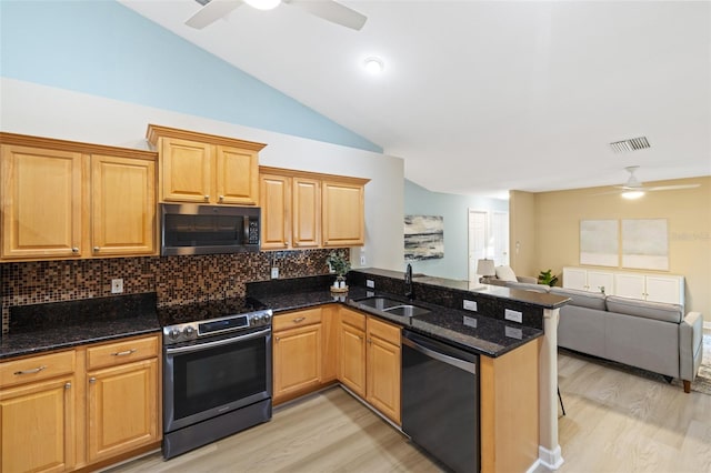 kitchen featuring sink, kitchen peninsula, stainless steel appliances, and dark stone counters