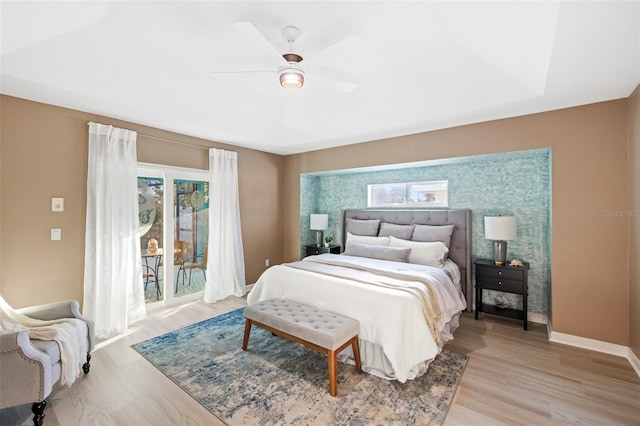 bedroom with access to outside, light hardwood / wood-style flooring, and ceiling fan