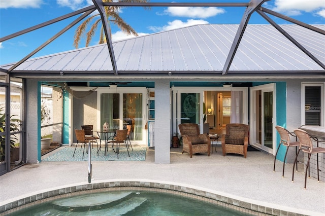 rear view of property with a lanai, ceiling fan, and a patio area