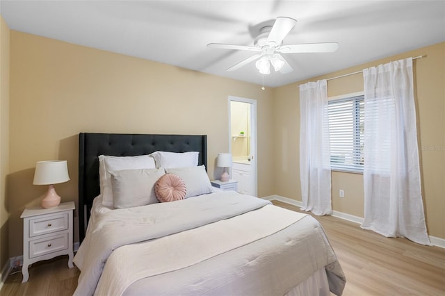 bedroom with ceiling fan, light hardwood / wood-style floors, and ensuite bathroom